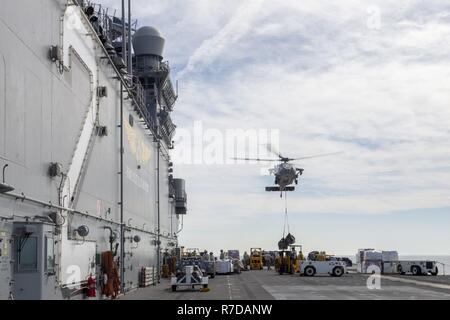 ARABIAN GULF (Nov. 28, 2018) Eine MH-60S Sea Hawk Hubschrauber, der "Blackjacks" der Hubschrauber Meer Combat Squadron (HSC) 21, Ladung das Flight Deck der Wasp-Klasse liefert Amphibisches Schiff USS Essex (LHD2) während eines geplanten Einsatz der Essex Amphibious Ready Group (ARG) und 13th Marine Expeditionary Unit (MEU). Das Essex ARG und 13. MEU sind eine flexible und beständige Navy-Marine Corps Team in die USA 5 Flotte Bereich der Maßnahme zur Unterstützung der Marine im Einsatz für die Stabilität und Sicherheit in der Region zu gewährleisten und verbindet das Mittelmeer und Stockfoto