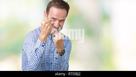 Stattliche mittleren Alter elegante älterer Mann über isolierte Hintergrund bereit mit Faust Verteidigung Geste zu kämpfen, wütend und verärgert Gesicht, Angst, Problem Stockfoto