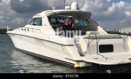 Zwei Coast Guard Station Fort Lauderdale 33-Fuß-Special Purpose Handwerk - Strafverfolgung boot Crewmitglieder die Durchführung einer Durchsuchung der 64-Fuß-Motoryacht, Cary auf die Baker's Haulover Bucht Montag, Dezember 3, 2018. Das Cary Auf der Reise war nach der Entdeckung mehrerer Sicherheit Verletzungen beendet. Stockfoto