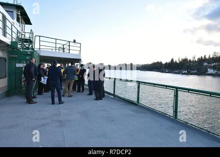 Mitglieder von Coast Guard Sektor Puget Sound, Washington State Ferries, die Crew des Schiffes und Kaleetan Kitsap County drücken Sie sammeln für eine Zeremonie auf der Südseite des Kaleetan auf dem Weg nach Seattle von Bremerton, Dez. 3, 2018. Die Zeremonie geehrt 2 Mate James Patheal und Able-Bodied Seaman Donna Phillips für die Rettungsmaßnahmen während an Bord des Schiffes Walla Wand August 16, 2018 arbeiten. Us-Küstenwache Stockfoto