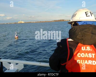 Der U.S. Coast Guard Cutter James Rankin Crewmitglieder entfernen Sie die Francis Scott Key Boje aus der Patapsco River in Baltimore für den Winter vorzubereiten, Dez. 3, 2018. Die speziell entwickelten Boje markiert die Stelle, wo Francis Scott Key die Beschießung von Fort McHenry erlebt und inspirierte ihn das 'Star Spangled Banner zu schreiben.' Stockfoto