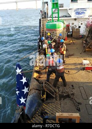 Der U.S. Coast Guard Cutter James Rankin Crewmitglieder entfernen Sie die Francis Scott Key Boje aus der Patapsco River in Baltimore für den Winter vorzubereiten, Dez. 3, 2018. Die speziell entwickelten Boje markiert die Stelle, wo Francis Scott Key die Beschießung von Fort McHenry erlebt und inspirierte ihn das 'Star Spangled Banner zu schreiben.' Stockfoto