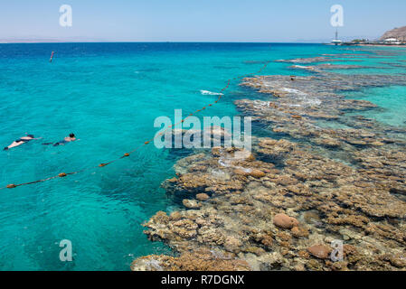 Türkisblauem Wasser und Unterwasser Korallen entlang leeren Strand im beliebten Ferienort Eilat am Roten Meer in Israel. Stockfoto