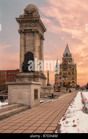 Eine vertikale Ansicht von Soldaten und Matrosen Denkmal an Clinton Square, Syracuse, New York mit der Syracuse Sparkasse an der Rückseite. Stockfoto