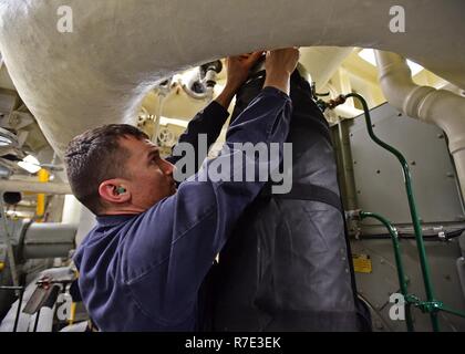 An Bord der USS BLUE RIDGE (Nov. 27, 2018) - Der Maschinist Mate 1. Klasse Alex Litovtchenko, aus St. Petersburg, Russland, zu den USA 7 Flotte Flaggschiff USS Blue Ridge LCC (19), nimmt an einem Engineering bohren beobachtet durch Flott Training Group (ATG) westlichen Pazifik. Blue Ridge ist das älteste operative Schiff der Marine, und als 7. Flotte Befehl Schiff, ist verantwortlich für die Patrouillen und die Förderung von Beziehungen innerhalb des Indo-Asia Pacific Region. Stockfoto