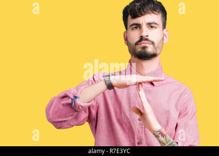Jungen gutaussehenden Mann mit rosa Shirt über isolierte Hintergrund tun time out Geste mit den Händen, frustriert und ernstes Gesicht Stockfoto