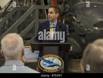 Thomas Saadi, Beauftragter des Connecticut Abteilung des Veterans Affairs, spricht mit einem Publikum während einer Zeremonie zu Ehren Korean War veteran Robert Rawlings, 27. November 2018 im New England Air Museum in Windsor Locks, Anschl. Saadi präsentiert Rawlings, der North American F-86 Sabre Jagdflugzeug im Kampf während des Koreakrieges flog, mit der Kommissarin Münze während der Zeremonie. Stockfoto