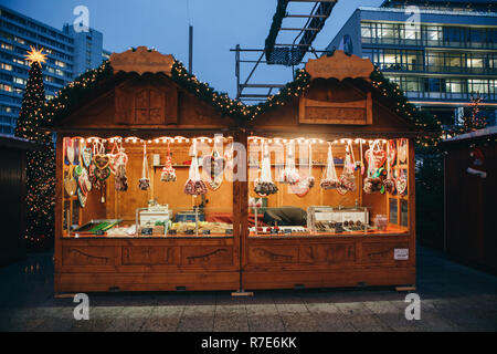 Berlin, den 25. Dezember 2017: Verkauf von Süßigkeiten und traditionellen Lebkuchen am Abend auf dem Weihnachtsmarkt in Berlin. Dekoriert. Stockfoto