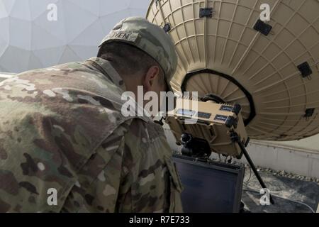Us-Armee Sgt. Kevin Nguyen, ein Teamleiter in der 50Th Expeditionary Signal Bataillon, testet die Verbindung eines Tampa Mikrowelle Sat-Schüssel in Camp Arifjan, Kuwait, Dez. 5, 2018. Ein Team von Soldaten aus den 50 ESB ist das Testen der Mobilität und Fähigkeiten Ihrer neuen Ausrüstung an Standorten auf der ganzen Welt. Diese neuen Satellitenschüssel Sätze sind viel leichter und einfacher zu transportieren als ältere Geräte, die Soldaten, die sich in streng Standorte schneller einzustellen. Stockfoto
