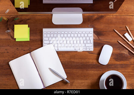 Schreibtisch mit Computer Monitor Tastatur öffnen Notebook und Kaffee, moderne Desktop-PC und liefert auf Arbeitsplatz braun Holz- Business Office Tabelle, dev Stockfoto