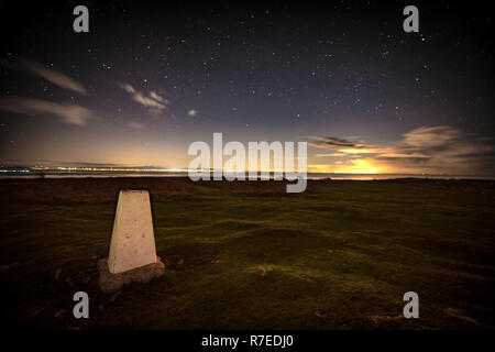 Blick von der Spitze des Birkrigg Gemeinsame, Ulverston, vorbei an der Trig Point und auf Lancaster, Morecambe und Blackpool auf der anderen Seite der Bucht ein Stockfoto