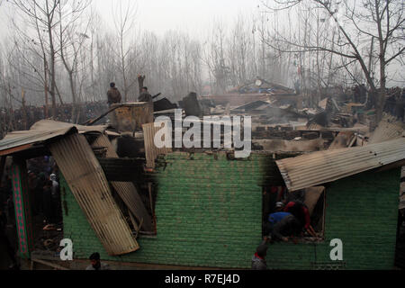 Srinagar, Indien. 9. Dez 2018. Kaschmirische Muslime sammelt bleibt beschädigten Hauses. Nach einer nächtlichen Begegnung, die am Rande des Dorfes an Mujgund brach, rund 11 km von Srinagar. am Samstag Abend. 3 Militante erschossen, Soldat verletzt In der Begegnung. Während der Operation, Sicherheitskräfte, flammte die Hälfte Wohnhäuser Dutzend beim Versuch, die Militanten, die sie zogen von Haus zu Haus die Sicherheitskräfte zu entziehen, zu neutralisieren. Wie ein Polizeisprecher mitteilte. © sofi Suhail/Alamy leben Nachrichten Stockfoto