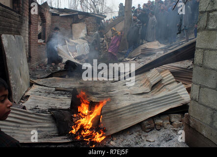 Srinagar, Indien. 9. Dez 2018. Kaschmirische Muslime beobachten beschädigten Hauses. Nach einer nächtlichen Begegnung, die am Rande des Dorfes an Mujgund brach, rund 11 km von Srinagar. am Samstag Abend. 3 Militante erschossen, Soldat verletzt In der Begegnung. Während der Operation, Sicherheitskräfte, flammte die Hälfte Wohnhäuser Dutzend beim Versuch, die Militanten, die sie zogen von Haus zu Haus die Sicherheitskräfte zu entziehen, zu neutralisieren. Wie ein Polizeisprecher mitteilte. © sofi Suhail/Alamy leben Nachrichten Stockfoto