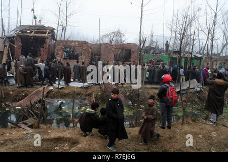 Srinagar, Indien. 9. Dez 2018. Kaschmirische Muslime beobachten beschädigten Hauses. Nach einer nächtlichen Begegnung, die am Rande des Dorfes an Mujgund brach, rund 11 km von Srinagar. am Samstag Abend. 3 Militante erschossen, Soldat verletzt In der Begegnung. Während der Operation, Sicherheitskräfte, flammte die Hälfte Wohnhäuser Dutzend beim Versuch, die Militanten, die sie zogen von Haus zu Haus die Sicherheitskräfte zu entziehen, zu neutralisieren. Wie ein Polizeisprecher mitteilte. © sofi Suhail/Alamy leben Nachrichten Stockfoto