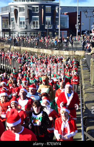 Admiral Cardiff 2018 Santa und Elf in der Walisischen Herzen liebe. Die größte festliche Sponsorenlauf in Wales in Cardiff Bay am Sonntag, den 9. Dezember stattfand Stockfoto