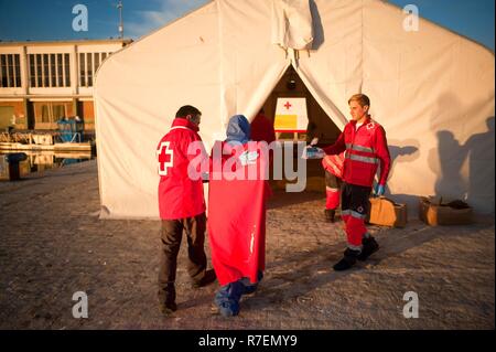 Malaga, Spanien. 9 Dez, 2018. Ein Mitglied des spanischen Roten Kreuzes gesehen helfen ein Wanderarbeitnehmer aus einem Zelt des spanischen Roten Kreuzes nach Ihrer Ankunft im Hafen von Málaga Spanien eingeben? Maritime Rescue Service gerettet Über 239 Migranten an Bord Jollen auf der Alboran See, und brachte sie nach Malaga Hafen, von wo aus sie durch das Spanische Rote Kreuz unterstützt wurden. Insgesamt wurden 27 Migranten gerettet am Samstag am Alboran Meer und die Straße von Gibraltar. Credit: Jesus Merida/SOPA Images/ZUMA Draht/Alamy leben Nachrichten Stockfoto