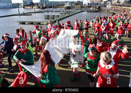 Admiral Cardiff 2018 Santa und Elf in der Walisischen Herzen liebe. Die größte festliche Sponsorenlauf in Wales in Cardiff Bay am Sonntag, den 9. Dezember stattfand Stockfoto