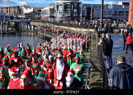 Admiral Cardiff 2018 Santa und Elf in der Walisischen Herzen liebe. Die größte festliche Sponsorenlauf in Wales in Cardiff Bay am Sonntag, den 9. Dezember stattfand Stockfoto