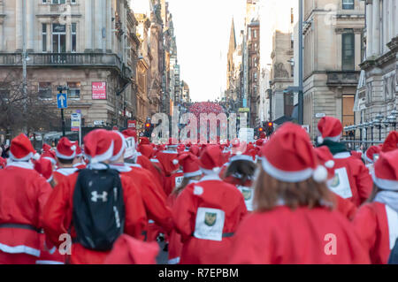 Glasgow, Schottland, Großbritannien. 9 Dezember, 2018: Tausende Läufer verkleidet als Weihnachtsmann nehmen an den jährlichen Santa Strich durch die Innenstadt in kalten Bedingungen in einem 5 k festliche Liebe Fun Run organisiert, um Mittel für gute Zwecke erheben. Nominiert ist in diesem Jahr die Nächstenliebe ist die Beatson Krebs Liebe. Credit: Skully/Alamy leben Nachrichten Stockfoto