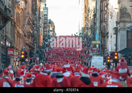 Glasgow, Schottland, Großbritannien. 9 Dezember, 2018: Tausende Läufer verkleidet als Weihnachtsmann nehmen an den jährlichen Santa Strich durch die Innenstadt in kalten Bedingungen in einem 5 k festliche Liebe Fun Run organisiert, um Mittel für gute Zwecke erheben. Nominiert ist in diesem Jahr die Nächstenliebe ist die Beatson Krebs Liebe. Credit: Skully/Alamy leben Nachrichten Stockfoto