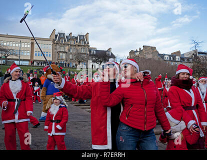 Edinburgh, Schottland, Großbritannien. 9. Dezember 2018. Santa ausführen. Edinburgh's Fundraising Santa's und Elfen lief, ging und schlenderte um West Princes Street Gardens, das Geld die Wünsche der Kinder für Wenn ein Stern zu gewähren. Trocken mit Temperatur von 7 Grad im Zentrum der Stadt. Stockfoto