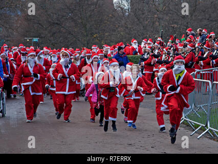 Edinburgh, Schottland, Großbritannien. 9. Dezember 2018. Santa ausführen. Edinburgh's Fundraising Santa's und Elfen lief, ging und schlenderte um West Princes Street Gardens, das Geld die Wünsche der Kinder für Wenn ein Stern zu gewähren. Trocken mit Temperatur von 7 Grad im Zentrum der Stadt. Stockfoto