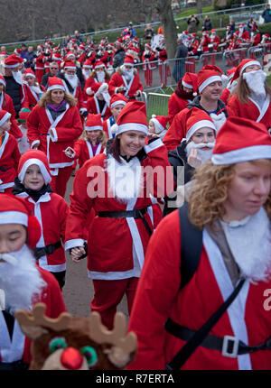 Edinburgh, Schottland, Großbritannien. 9. Dezember 2018. Santa ausführen. Edinburgh's Fundraising Santa's und Elfen lief, ging und schlenderte um West Princes Street Gardens, das Geld die Wünsche der Kinder für Wenn ein Stern zu gewähren. Trocken mit Temperatur von 7 Grad im Zentrum der Stadt. Stockfoto