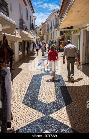 Lagos, Portugal - 27. Juni 2018: Touristen halten an Geschäften entlang der gefliesten Straßen von Lagos an einem sonnigen Tag. Stockfoto