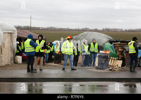 Roppenheim, Frankreich. 08 Dez, 2018. Die Demonstranten haben ein paar Zelte auf der Seite der Straße. Eine alte oilcan mit brennenden Holz es ist für das Aufwärmen verwendet. Rund 100 Französische gelbe Weste Aktivisten protestierten auf einer Straße in der Nähe der Französisch Deutsch Grenzübergang bei Roppenheim gegen die französische Regierung. Sie wurden von einigen Aktivistinnen aus der Deutschen rechten Gruppen unterstützt. Sie waren Teil der grösseren gelbe Weste Protestbewegung in Frankreich, die in den vergangenen 4 Wochen in ganz Frankreich protestiert. Quelle: Michael Debets/Pacific Press/Alamy leben Nachrichten Stockfoto