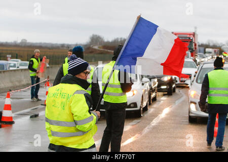 Roppenheim, Frankreich. 08 Dez, 2018. Demonstranten blockieren den Verkehr für eine kurze Weile. Ich Demonstranten trägt eine französische Flagge. Rund 100 Französische gelbe Weste Aktivisten protestierten auf einer Straße in der Nähe der Französisch Deutsch Grenzübergang bei Roppenheim gegen die französische Regierung. Sie wurden von einigen Aktivistinnen aus der Deutschen rechten Gruppen unterstützt. Sie waren Teil der grösseren gelbe Weste Protestbewegung in Frankreich, die in den vergangenen 4 Wochen in ganz Frankreich protestiert. Quelle: Michael Debets/Pacific Press/Alamy leben Nachrichten Stockfoto
