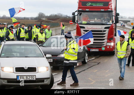 Roppenheim, Frankreich. 08 Dez, 2018. Autos fahren durch den Protest. Die Demonstranten jubeln, wenn die Treiber ihre Unterstützung zeigen. Rund 100 Französische gelbe Weste Aktivisten protestierten auf einer Straße in der Nähe der Französisch Deutsch Grenzübergang bei Roppenheim gegen die französische Regierung. Sie wurden von einigen Aktivistinnen aus der Deutschen rechten Gruppen unterstützt. Sie waren Teil der grösseren gelbe Weste Protestbewegung in Frankreich, die in den vergangenen 4 Wochen in ganz Frankreich protestiert. Quelle: Michael Debets/Pacific Press/Alamy leben Nachrichten Stockfoto