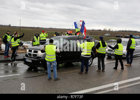 Roppenheim, Frankreich. 08 Dez, 2018. Autos fahren durch den Protest. Die Demonstranten jubeln, wenn die Treiber ihre Unterstützung zeigen. Rund 100 Französische gelbe Weste Aktivisten protestierten auf einer Straße in der Nähe der Französisch Deutsch Grenzübergang bei Roppenheim gegen die französische Regierung. Sie wurden von einigen Aktivistinnen aus der Deutschen rechten Gruppen unterstützt. Sie waren Teil der grösseren gelbe Weste Protestbewegung in Frankreich, die in den vergangenen 4 Wochen in ganz Frankreich protestiert. Quelle: Michael Debets/Pacific Press/Alamy leben Nachrichten Stockfoto
