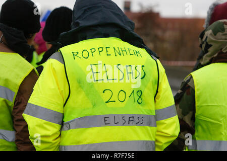 Roppenheim, Frankreich. 08 Dez, 2018. Einen Demonstranten trägt eine gelbe Weste mit 'Roppenheim Elsass 2018' auf. Rund 100 Französische gelbe Weste Aktivisten protestierten auf einer Straße in der Nähe der Französisch Deutsch Grenzübergang bei Roppenheim gegen die französische Regierung. Sie wurden von einigen Aktivistinnen aus der Deutschen rechten Gruppen unterstützt. Sie waren Teil der grösseren gelbe Weste Protestbewegung in Frankreich, die in den vergangenen 4 Wochen in ganz Frankreich protestiert. Quelle: Michael Debets/Pacific Press/Alamy leben Nachrichten Stockfoto