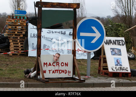 Roppenheim, Frankreich. 08 Dez, 2018. Eine gefälschte Guillotine steht auf der Seite der Straße, mit einem Bild des französischen Präsidenten Emmanuel Längestrich und die Schrift 'MAcron, wir warten auf Sie. Rund 100 Französische gelbe Weste Aktivisten protestierten auf einer Straße in der Nähe der Französisch Deutsch Grenzübergang bei Roppenheim gegen die französische Regierung. Sie wurden von einigen Aktivistinnen aus der Deutschen rechten Gruppen unterstützt. Sie waren Teil der grösseren gelbe Weste Protestbewegung in Frankreich, die in den vergangenen 4 Wochen in ganz Frankreich protestiert. Quelle: Michael Debets/Pacific Press/Alamy leben Nachrichten Stockfoto