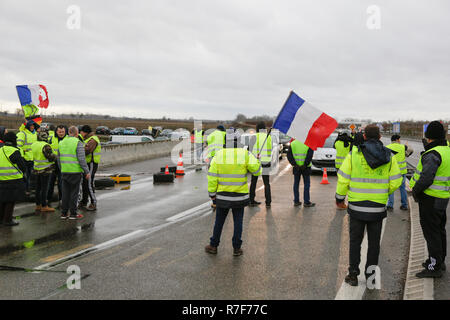 Roppenheim, Frankreich. 08 Dez, 2018. Demonstranten blockieren den Verkehr für eine kurze Weile. Ich Demonstranten trägt eine französische Flagge. Rund 100 Französische gelbe Weste Aktivisten protestierten auf einer Straße in der Nähe der Französisch Deutsch Grenzübergang bei Roppenheim gegen die französische Regierung. Sie wurden von einigen Aktivistinnen aus der Deutschen rechten Gruppen unterstützt. Sie waren Teil der grösseren gelbe Weste Protestbewegung in Frankreich, die in den vergangenen 4 Wochen in ganz Frankreich protestiert. Quelle: Michael Debets/Pacific Press/Alamy leben Nachrichten Stockfoto
