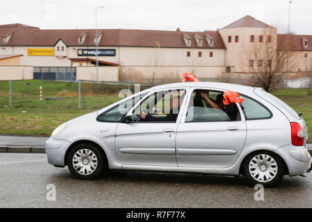 Roppenheim, Frankreich. 08 Dez, 2018. Ein Treiber Wellen eines orangefarbenen Westen von seinem Auto. Rund 100 Französische gelbe Weste Aktivisten protestierten auf einer Straße in der Nähe der Französisch Deutsch Grenzübergang bei Roppenheim gegen die französische Regierung. Sie wurden von einigen Aktivistinnen aus der Deutschen rechten Gruppen unterstützt. Sie waren Teil der grösseren gelbe Weste Protestbewegung in Frankreich, die in den vergangenen 4 Wochen in ganz Frankreich protestiert. Quelle: Michael Debets/Pacific Press/Alamy leben Nachrichten Stockfoto