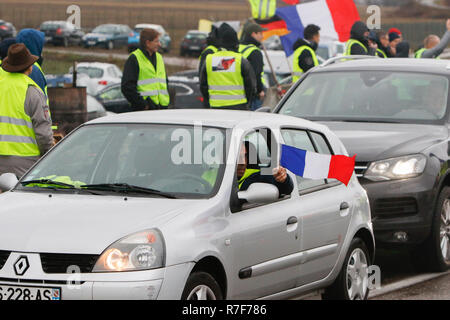 Roppenheim, Frankreich. 08 Dez, 2018. Ein Treiber Wellen eine französische Flagge von seinem Auto. Rund 100 Französische gelbe Weste Aktivisten protestierten auf einer Straße in der Nähe der Französisch Deutsch Grenzübergang bei Roppenheim gegen die französische Regierung. Sie wurden von einigen Aktivistinnen aus der Deutschen rechten Gruppen unterstützt. Sie waren Teil der grösseren gelbe Weste Protestbewegung in Frankreich, die in den vergangenen 4 Wochen in ganz Frankreich protestiert. Quelle: Michael Debets/Pacific Press/Alamy leben Nachrichten Stockfoto