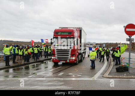 Roppenheim, Frankreich. 08 Dez, 2018. Ein Truck fährt durch die protestieren. Die Demonstranten jubeln, wenn die Treiber ihre Unterstützung zeigen. Rund 100 Französische gelbe Weste Aktivisten protestierten auf einer Straße in der Nähe der Französisch Deutsch Grenzübergang bei Roppenheim gegen die französische Regierung. Sie wurden von einigen Aktivistinnen aus der Deutschen rechten Gruppen unterstützt. Sie waren Teil der grösseren gelbe Weste Protestbewegung in Frankreich, die in den vergangenen 4 Wochen in ganz Frankreich protestiert. Quelle: Michael Debets/Pacific Press/Alamy leben Nachrichten Stockfoto