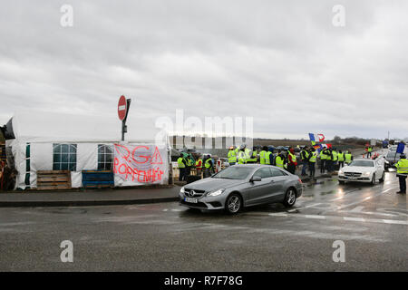 Roppenheim, Frankreich. 08 Dez, 2018. Autos fahren durch den Protest. Die Demonstranten jubeln, wenn die Treiber ihre Unterstützung zeigen. Rund 100 Französische gelbe Weste Aktivisten protestierten auf einer Straße in der Nähe der Französisch Deutsch Grenzübergang bei Roppenheim gegen die französische Regierung. Sie wurden von einigen Aktivistinnen aus der Deutschen rechten Gruppen unterstützt. Sie waren Teil der grösseren gelbe Weste Protestbewegung in Frankreich, die in den vergangenen 4 Wochen in ganz Frankreich protestiert. Quelle: Michael Debets/Pacific Press/Alamy leben Nachrichten Stockfoto