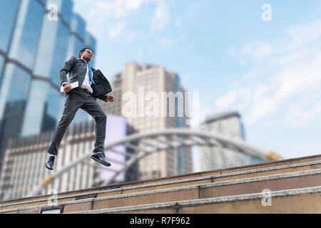 Ein Geschäftsmann schweben über dem Boden mit dem Gebäude im Hintergrund Stockfoto