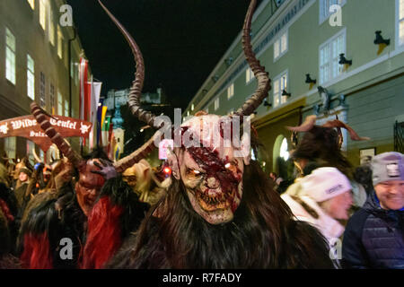 Salzburg: Krampuslauf (Krampus-Lauf, Perchtenlauf, Krampus, Maske Prozession) in der Altstadt in der Straße, in der hofstallgasse zurück Burg Hohensalzburg Stockfoto