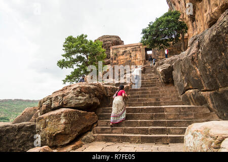 Eine Frau in der traditionellen saree Spaziergänge auf den Stufen der Badami Höhlentempeln in Badami in Karnataka, Indien. Stockfoto