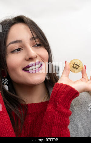 Lächelnde Frau mit einem Goldenen Bitcoin Stockfoto