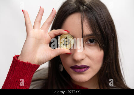 Schwere Frau mit einem bitcoin vor ihrem rechten Auge Stockfoto