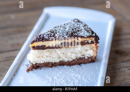 Kokosnuss Kuchen auf weiße Platte auf rustikalen Holztisch Stockfoto