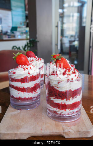 Strawberry trifle im Glas mit frischen Erdbeeren auf Holzplatte Stockfoto
