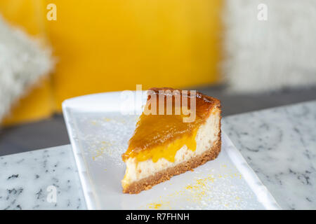 Lecker mango lime Cheesecake auf weiße Platte Stockfoto