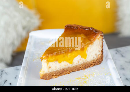 Lecker mango lime Cheesecake auf weiße Platte Stockfoto