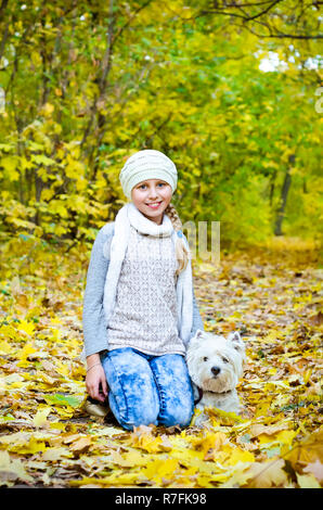 Mädchen mit West Highland White Terrier im Park Stockfoto