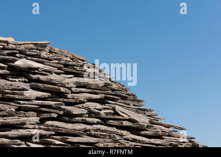 Alte Dach mit grauen Stein Fliesen und klaren blauen Himmel im Hintergrund Stockfoto